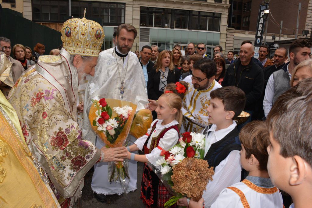 A young child greets His Grace Bishop Irinej of the Serbian Orthodox Church