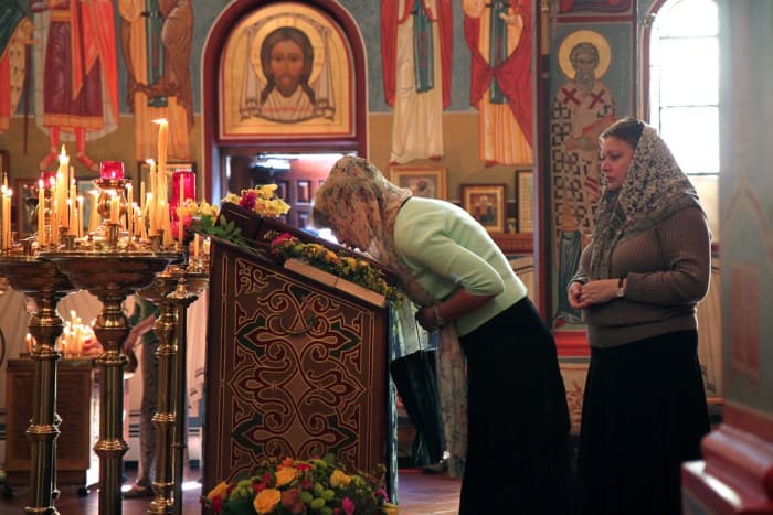 Orthodox women kissing an icon