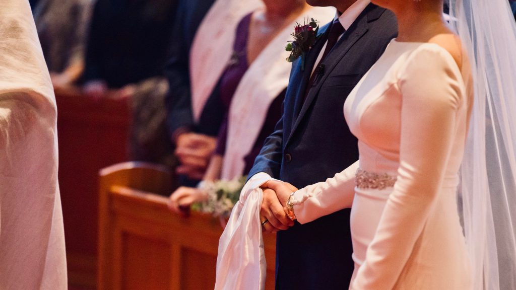 Bride and groom holding hands in a wedding in an Orthodox Church