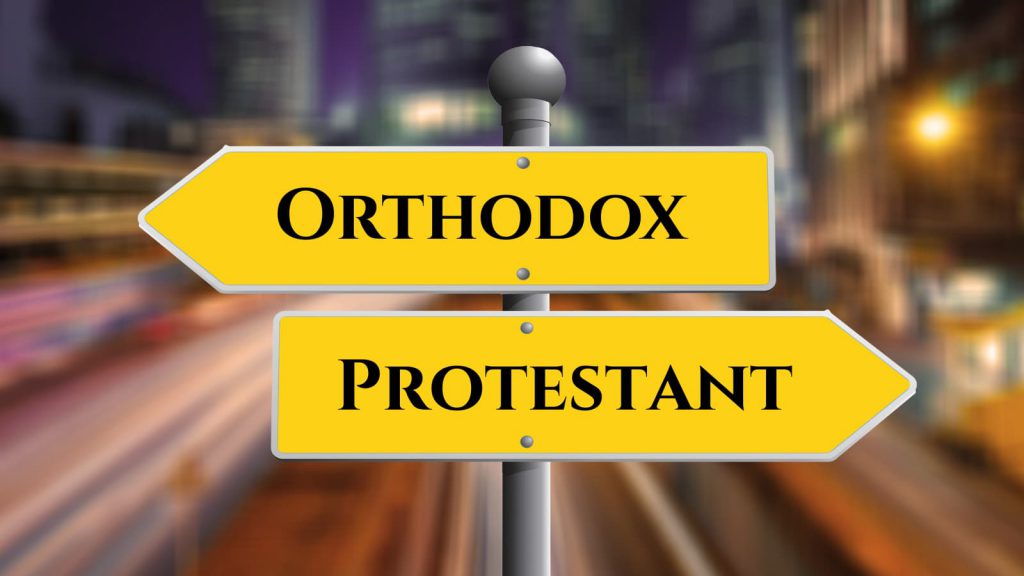 Road sign pointing left and right. One sign says Orthodox, and the other says Protestant.