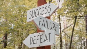 Road sign that says success, failure, and defeat